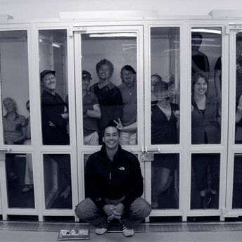 David Vadiveloo posing with the cast and crew in the holding cells at the police station.