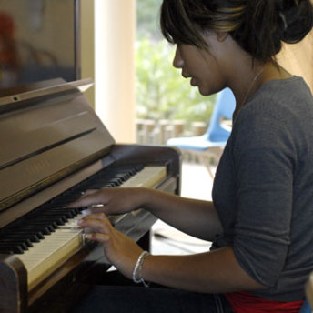 An attendee of the Community Prophets workshop playing a piano.